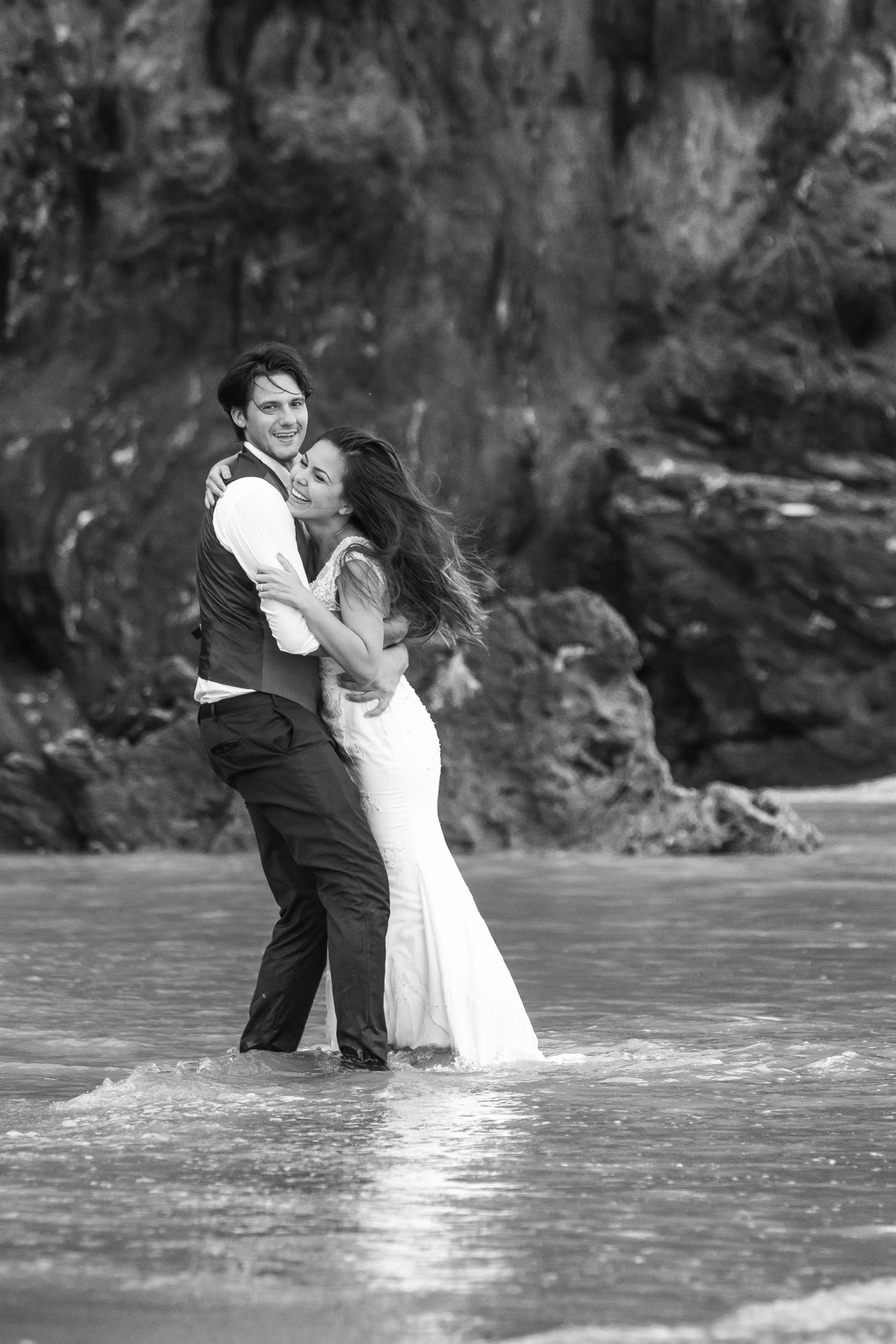 Newlyweds embracing in the water during a dramatic trash-the-dress portrait