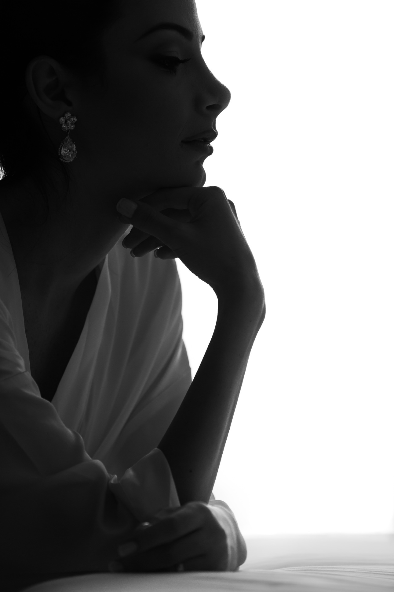 Artistic black-and-white profile silhouette of a bride wearing elegant drop earrings