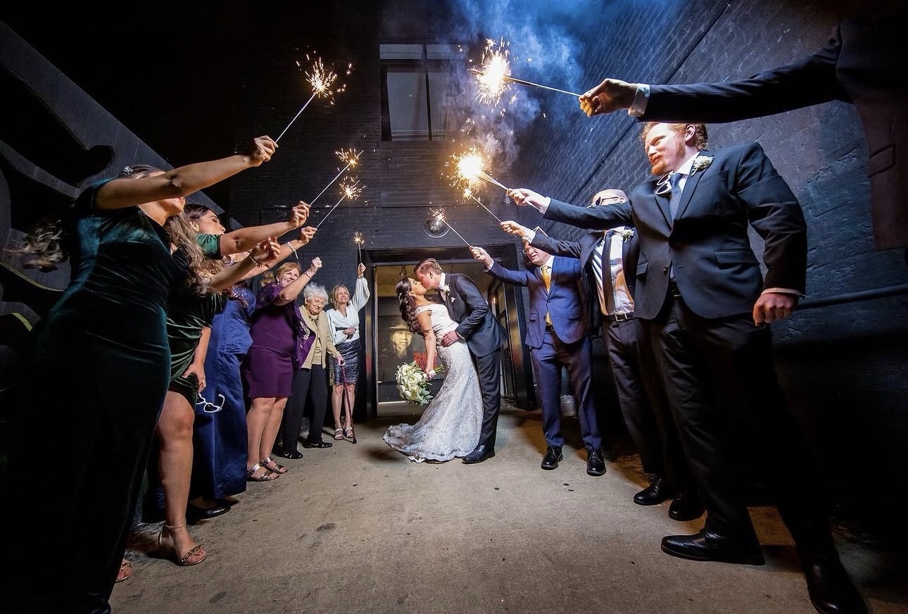 Newlyweds kissing during a sparkling nighttime wedding exit